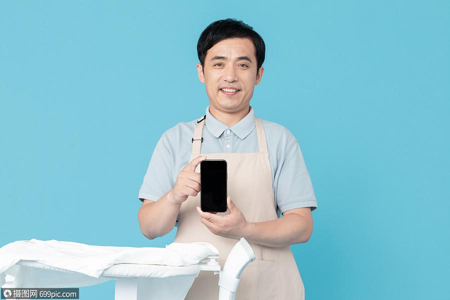 拿手机的家政服务男性认真保洁人员